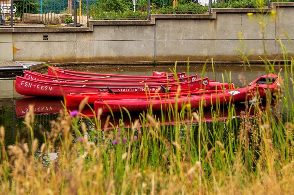 Rote Kanus auf dem Karl-Heine-Kanal in Leipzig – jetzt Wassersport und Teamwork bei einer Klassenfahrt nach Leipzig erleben!